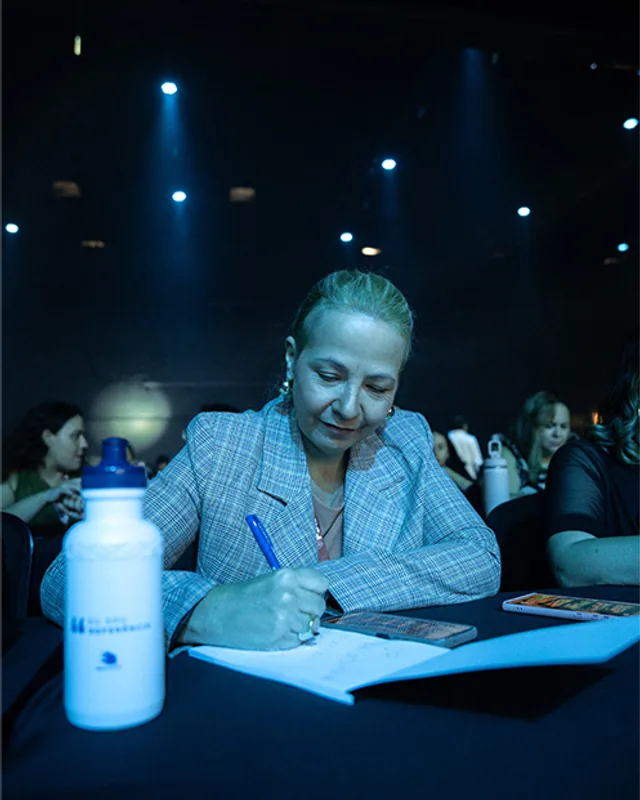 Participante fazendo anotações durante uma palestra do congresso